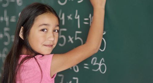 Girl making some exercises on the blackboard