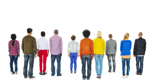 A diverse group of people standing, with their backs facing the viewer